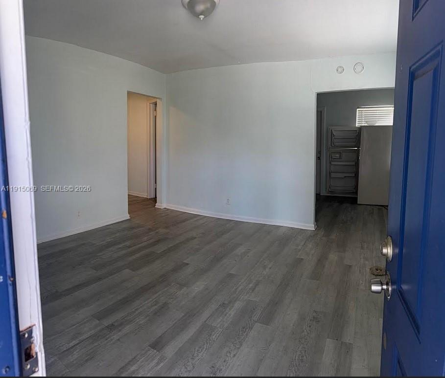 An interior view of a room with light gray walls and wood-look laminate flooring — 817 Grant St, West Palm Beach FL 33407, WEST PALM BEACH, FL