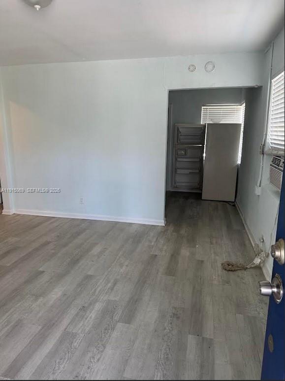 An interior view of a room with light-colored wood-look flooring and an adjacent kitchen area — 817 Grant St, West Palm Beach FL 33407, WEST PALM BEACH, FL