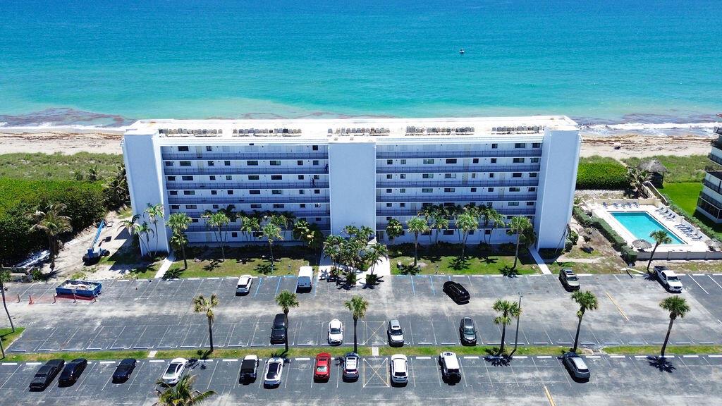 An aerial view of a multi-story apartment building with a parking lot and swimming pool — 10102 S Ocean Drive # 204a, Jensen Beach FL 34957, JENSEN BEACH, FL