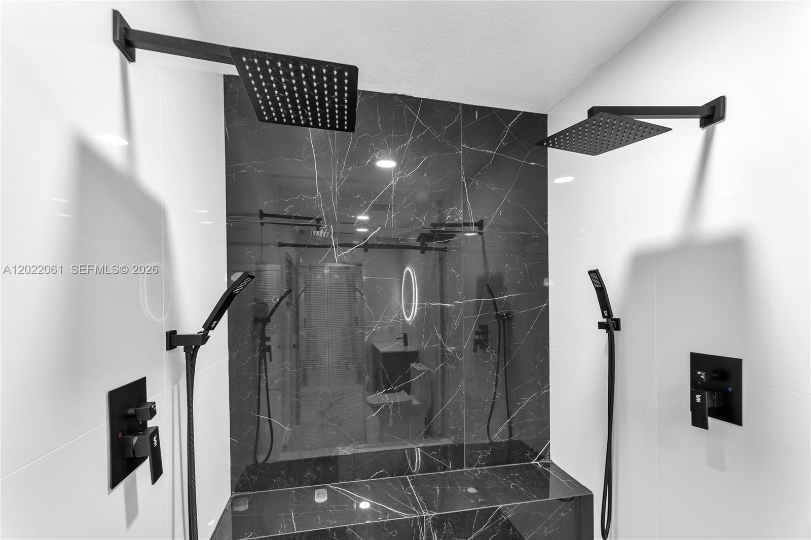 A modern shower features dual rainfall heads, handheld sprayers, and black marble-patterned tile walls — 1541 NW 1st Ct, Miami FL 33136, MIAMI, FL