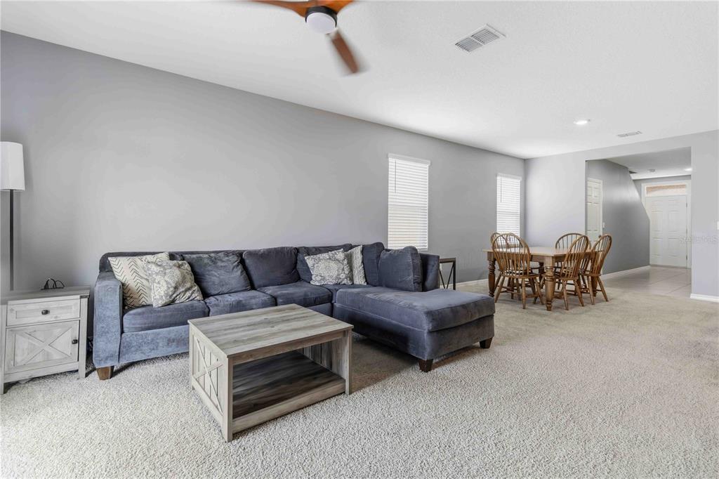 A living room features a gray sectional sofa, a wooden coffee table, and a dining area — 1156 VALLEY VIEW AVENUE, ROCKLEDGE, FL