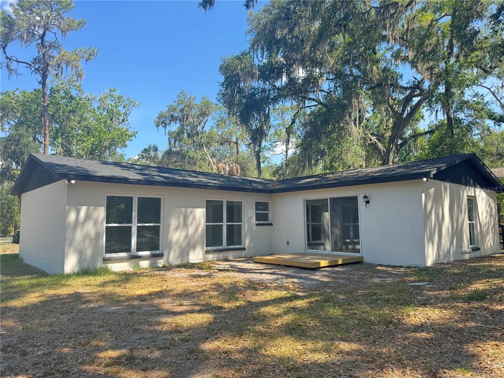 A single-story house with a white exterior, a red front door, and a dark garage — 4405 COCONUT COVE PLACE, VALRICO, FL