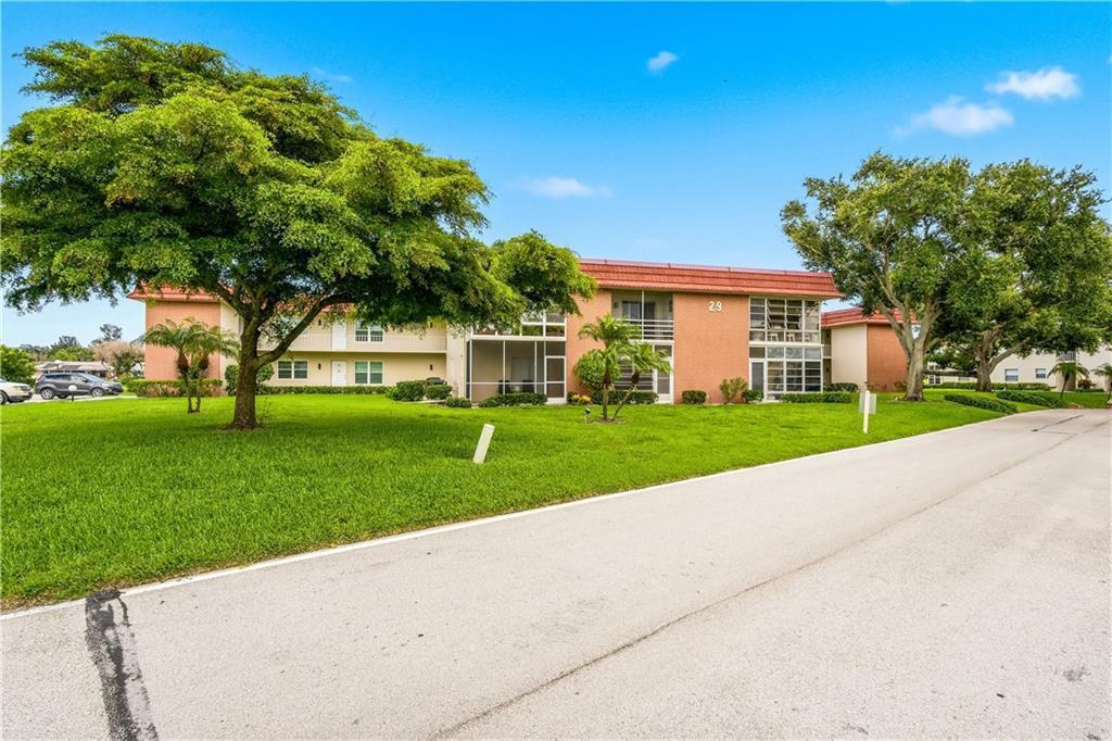 A two-story apartment building with a peach-colored exterior and a red roof — VERO BEACH, FL