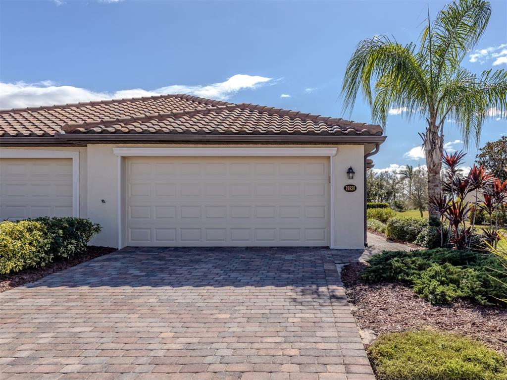 A living room features a white sectional sofa, glass coffee table, and a wall-mounted television — 19930 BENISSIMO DRIVE, VENICE, FL
