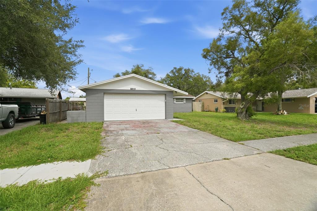 A single-story house with a white garage door and a concrete driveway — 8855 53RD WAY N, PINELLAS PARK, FL
