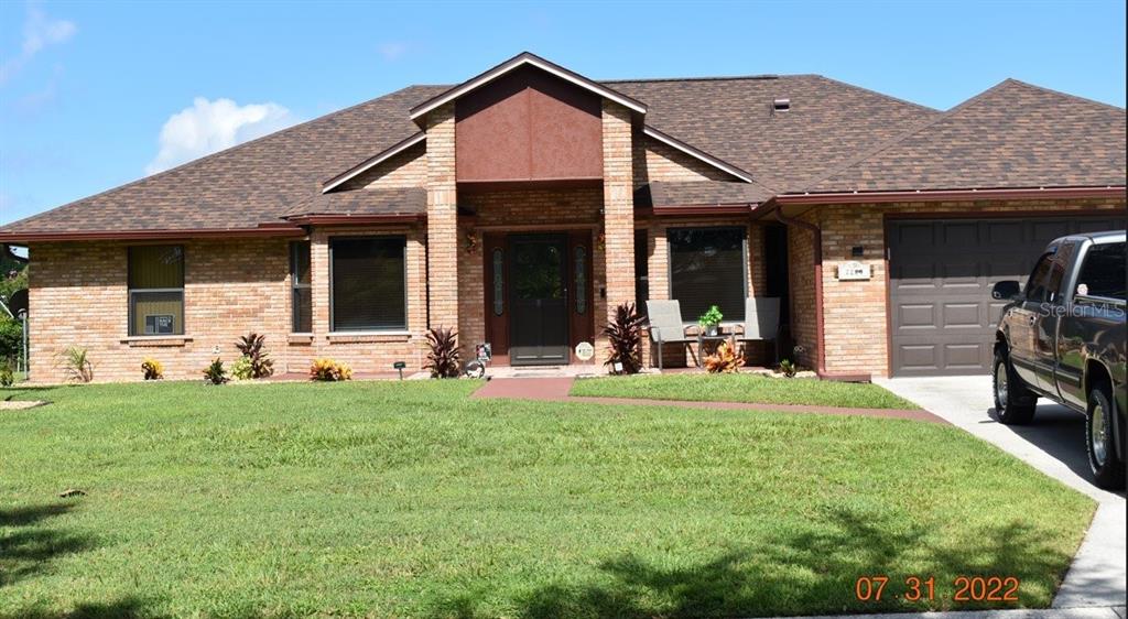 A single-story brick house with a brown shingled roof and an attached two-car garage — 2220 EMPEROR DRIVE, KISSIMMEE, FL