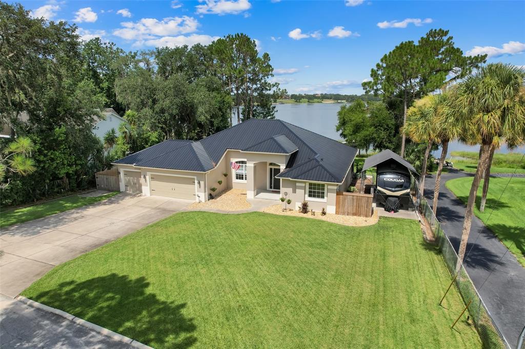 An aerial view shows a house with a red location pin beside a large lake — 18233 ROSE STREET, GROVELAND, FL