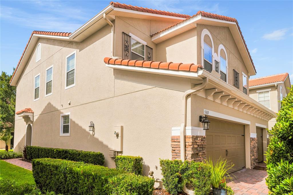 A two-story beige stucco house with a tiled roof and an attached garage — 5369 VIA APPIA WAY, SANFORD, FL