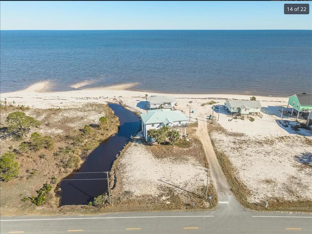 An aerial view shows a coastal house situated between a small creek and the ocean — 3 MARLIN STREET, PANACEA, FL