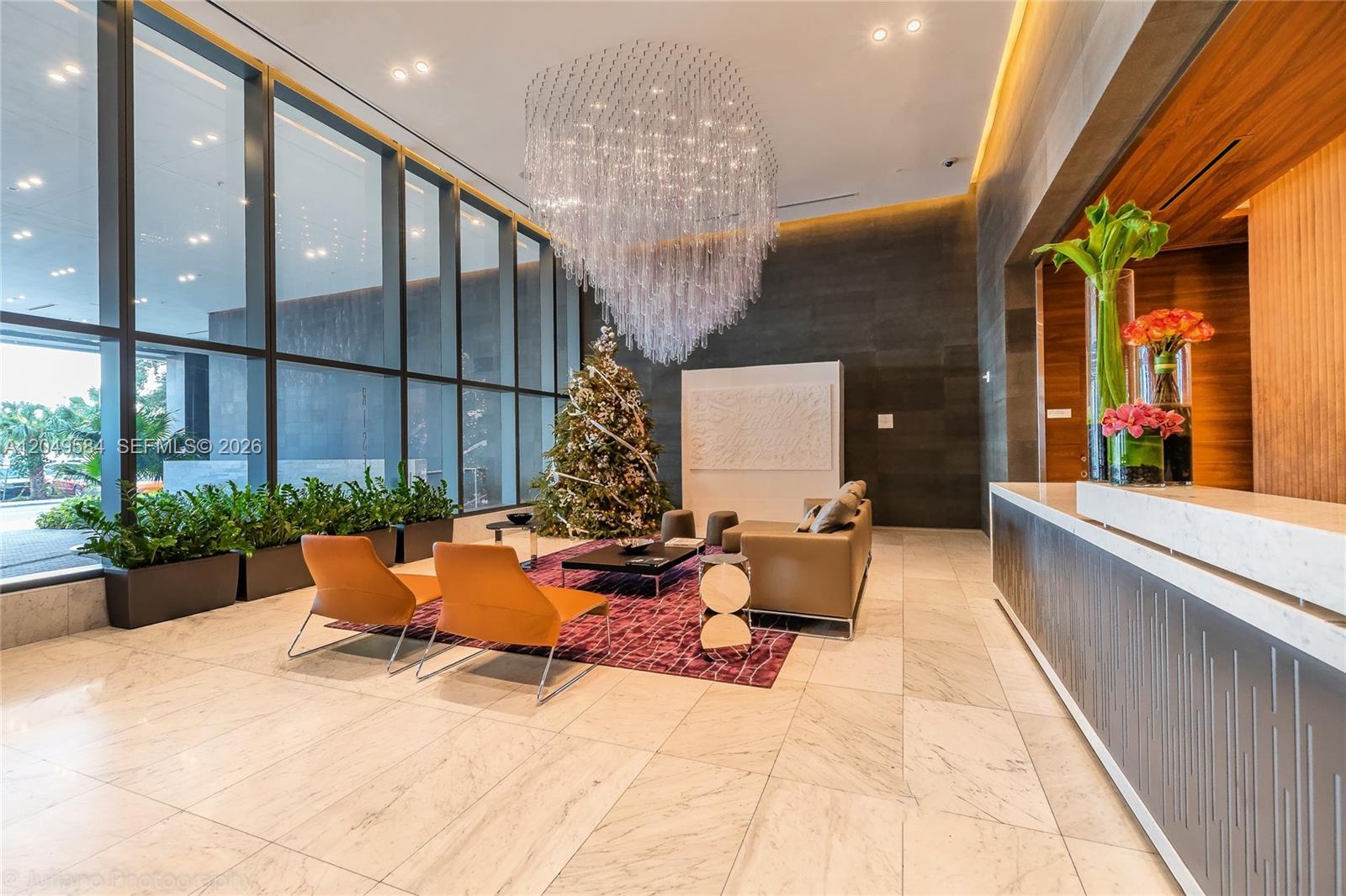 A modern lobby features a large crystal chandelier, marble floors, and a seating area — 88 SW 7th St # 2401, Miami FL 33130, MIAMI, FL