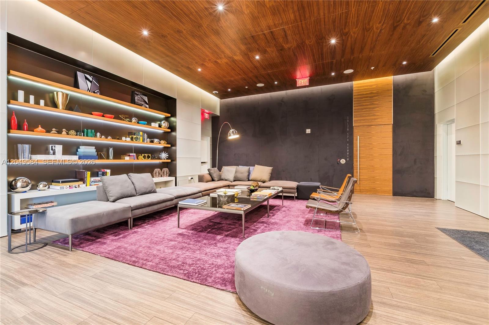 A modern lounge area features a large purple rug, gray sectional sofa, and wood-paneled ceiling — 88 SW 7th St # 2401, Miami FL 33130, MIAMI, FL