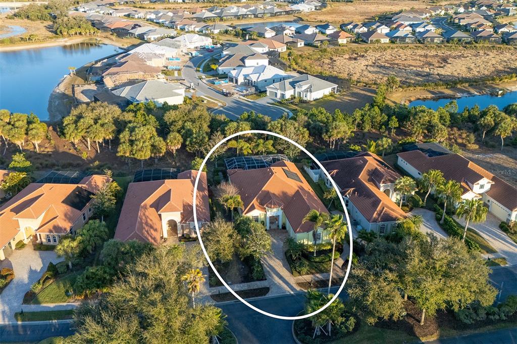 An aerial view shows a single-story house with a tile roof and a screened pool — 1752 GRANDE PARK DRIVE, ENGLEWOOD, FL