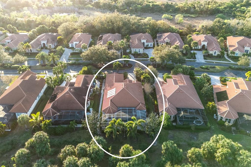An aerial view shows a residential house with a tiled roof and a screened-in pool — 1752 GRANDE PARK DRIVE, ENGLEWOOD, FL