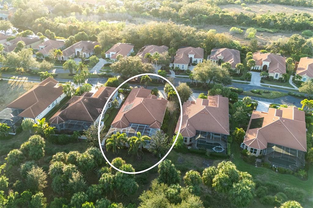 An aerial view shows a residential house with a screened pool enclosure and tiled roof — 1752 GRANDE PARK DRIVE, ENGLEWOOD, FL