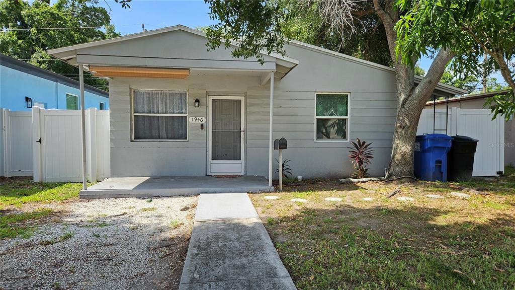 A gray single-story house with a front porch, a concrete walkway, and a white fence — 1946 15TH AVENUE S, ST PETERSBURG, FL