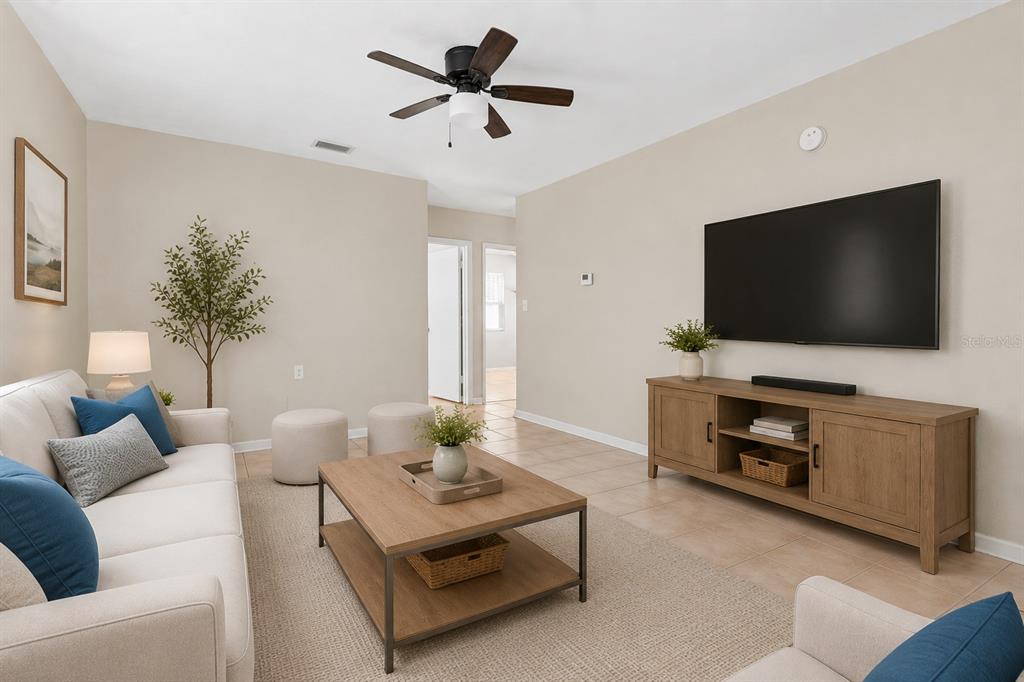 A living room features a beige sofa, a wooden coffee table, and a wall-mounted television — 1946 15TH AVENUE S, ST PETERSBURG, FL