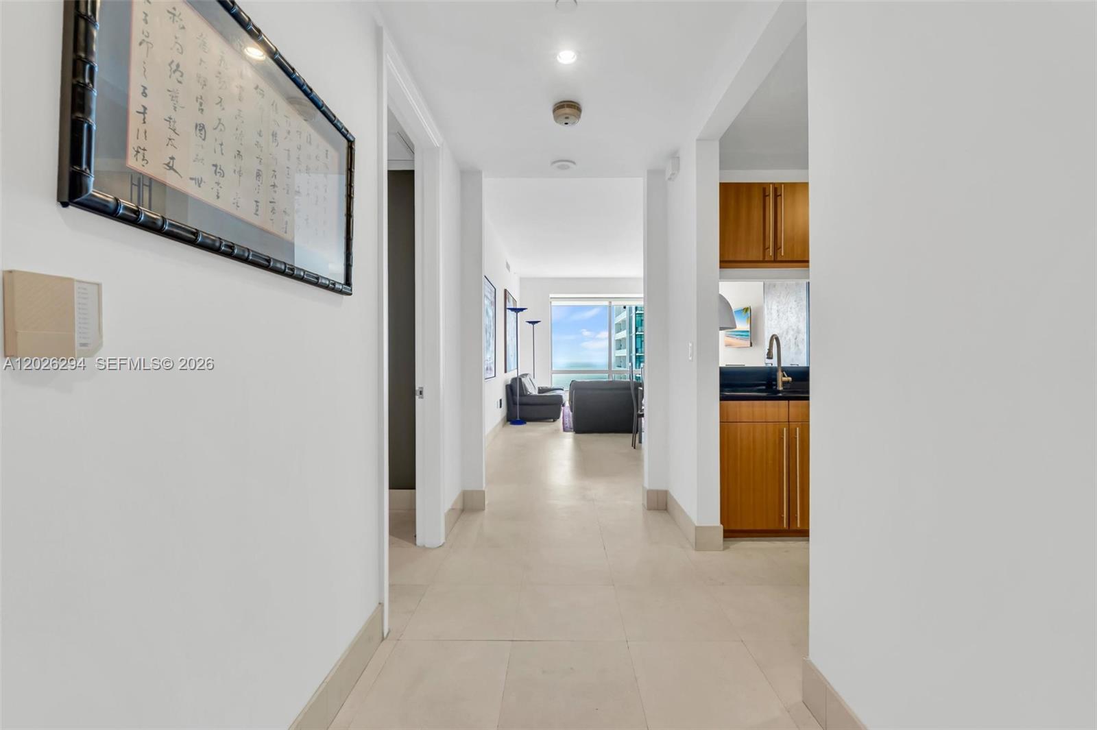 A hallway with light tile floors leads toward a living area with ocean views — 1425 Brickell Ave # 51A, Miami FL 33131, MIAMI, FL