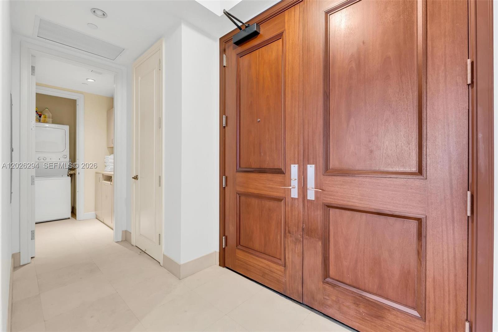 A hallway features a double wooden door, a white door, and a laundry area — 1425 Brickell Ave # 51A, Miami FL 33131, MIAMI, FL