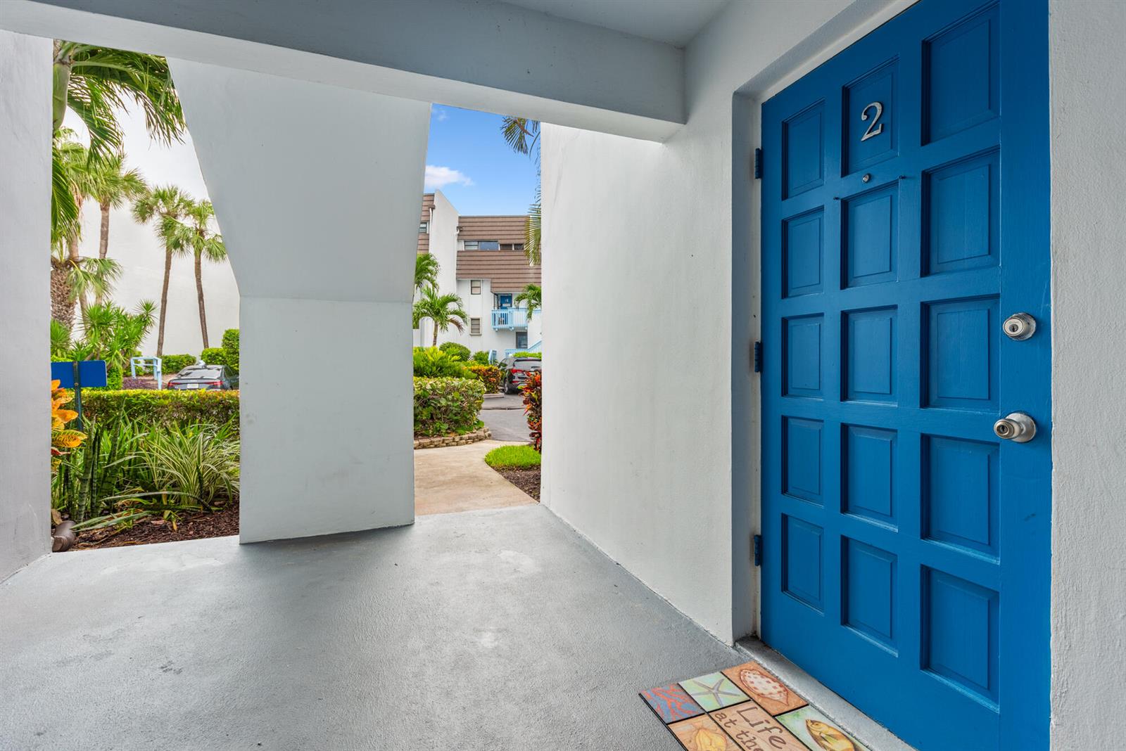 A bright blue front door marked with the number two opens onto a concrete porch — 11000 S Ocean Drive # 2, Jensen Beach FL 34957, JENSEN BEACH, FL