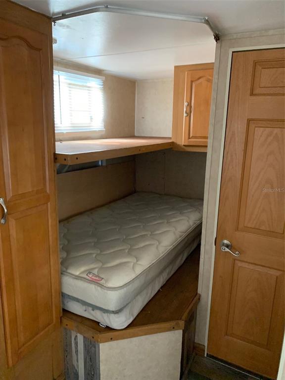A small bedroom features a bunk bed with a mattress and light wood cabinetry — 3000 CLARCONA ROAD UNIT 333, APOPKA, FL