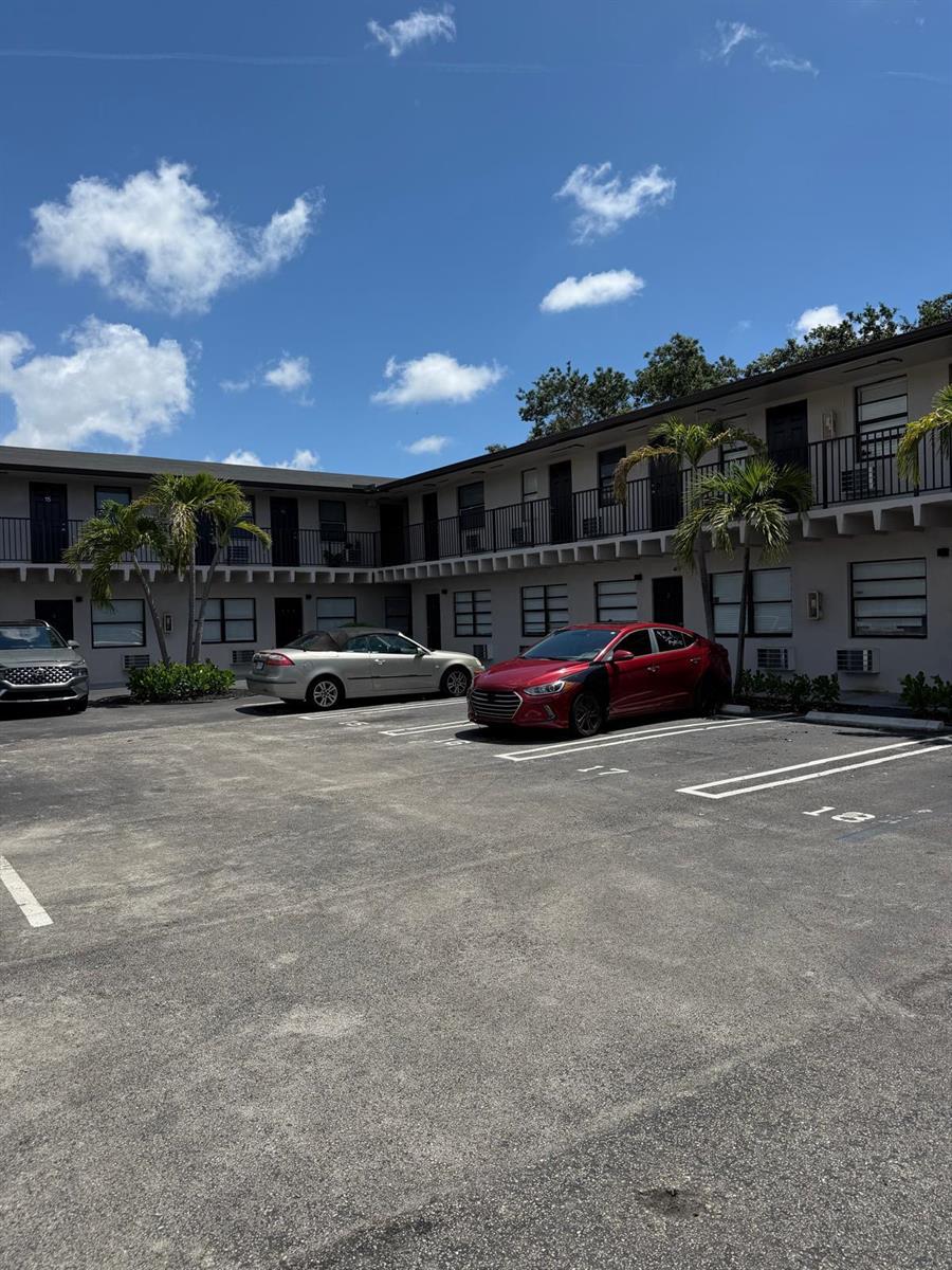 A two-story apartment building with a parking lot in front under a blue sky — 110 NW 7th Avenue # 18, Pompano Beach FL 33060, POMPANO BEACH, FL