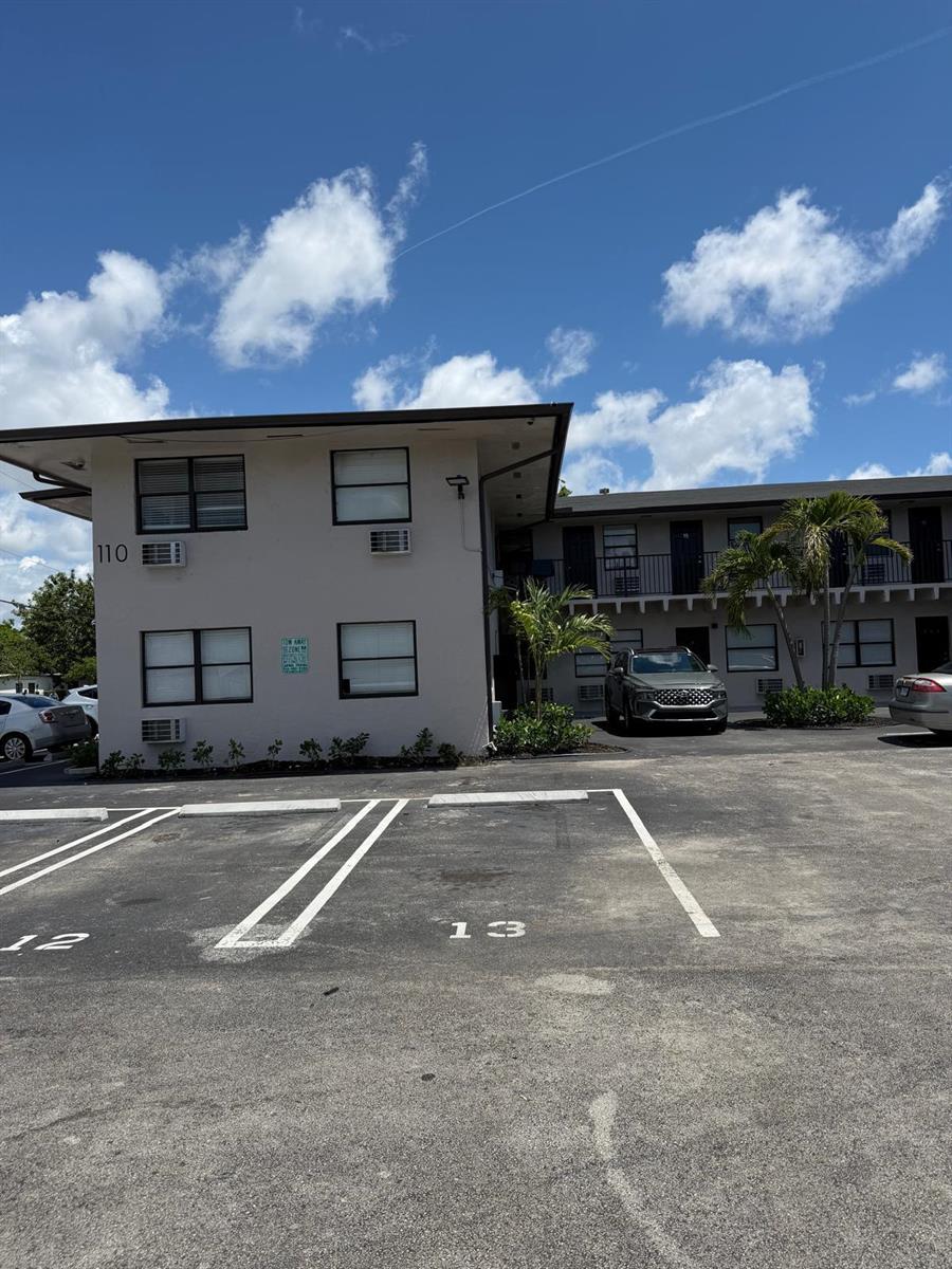 A two-story apartment building with a parking lot in the foreground — 110 NW 7th Avenue # 18, Pompano Beach FL 33060, POMPANO BEACH, FL
