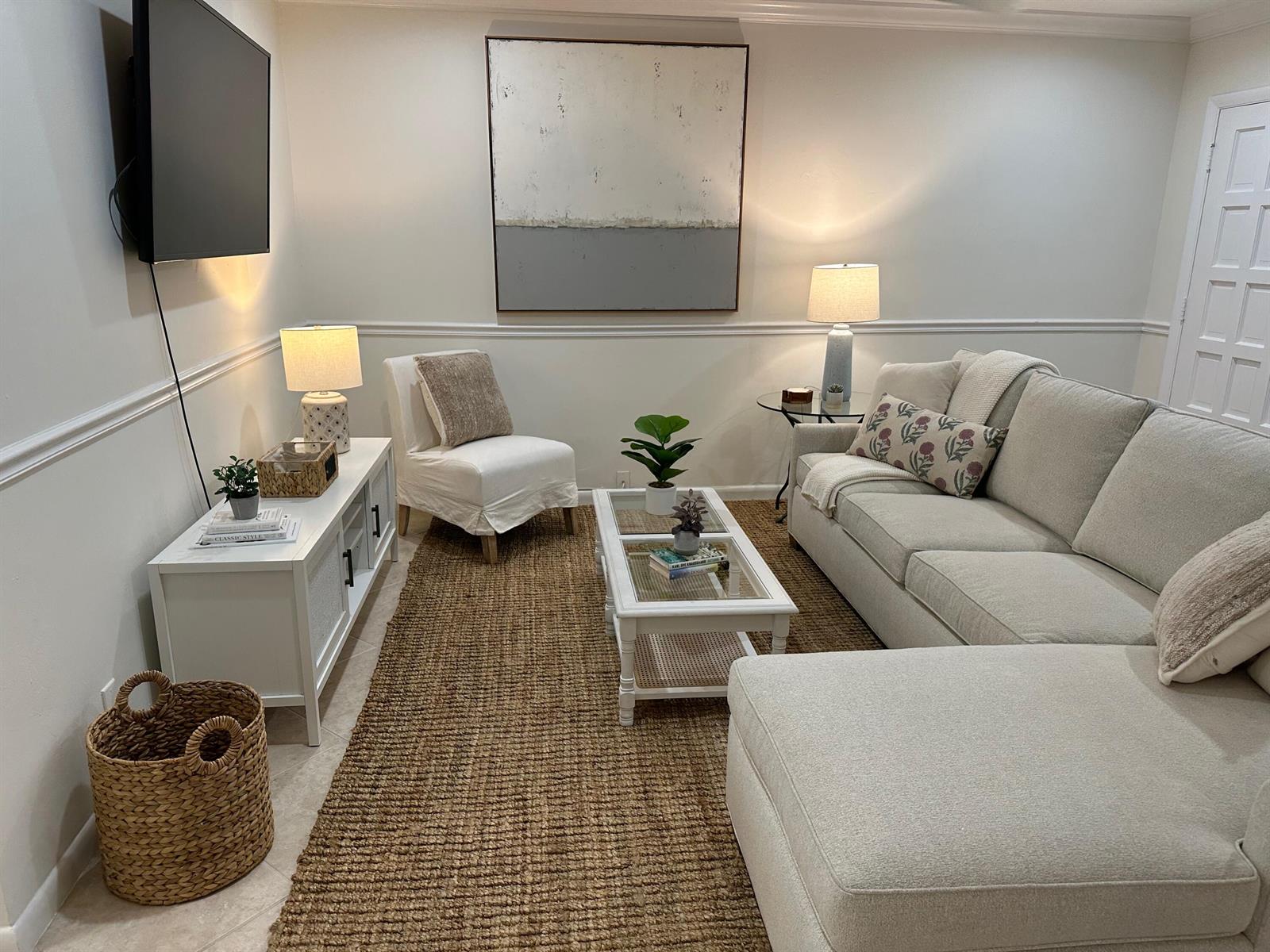 A living room features a sectional sofa, a white coffee table, and a woven area rug — 1202 Palm Trail # 6, Delray Beach FL 33483, DELRAY BEACH, FL