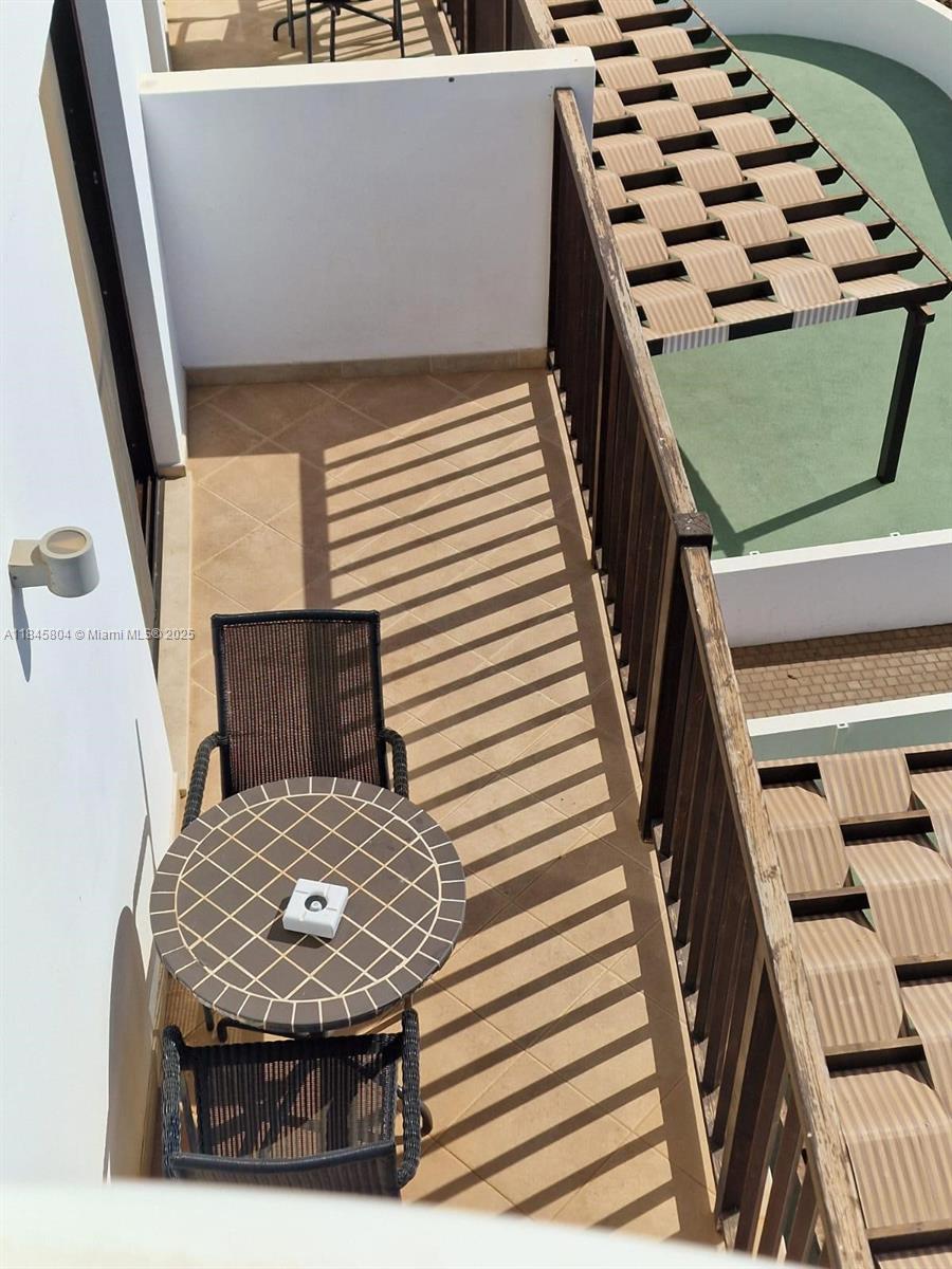 A small balcony features a round table, two chairs, and a wooden railing — 4110 Rua Andrade Corvo # 6087, FL, FL