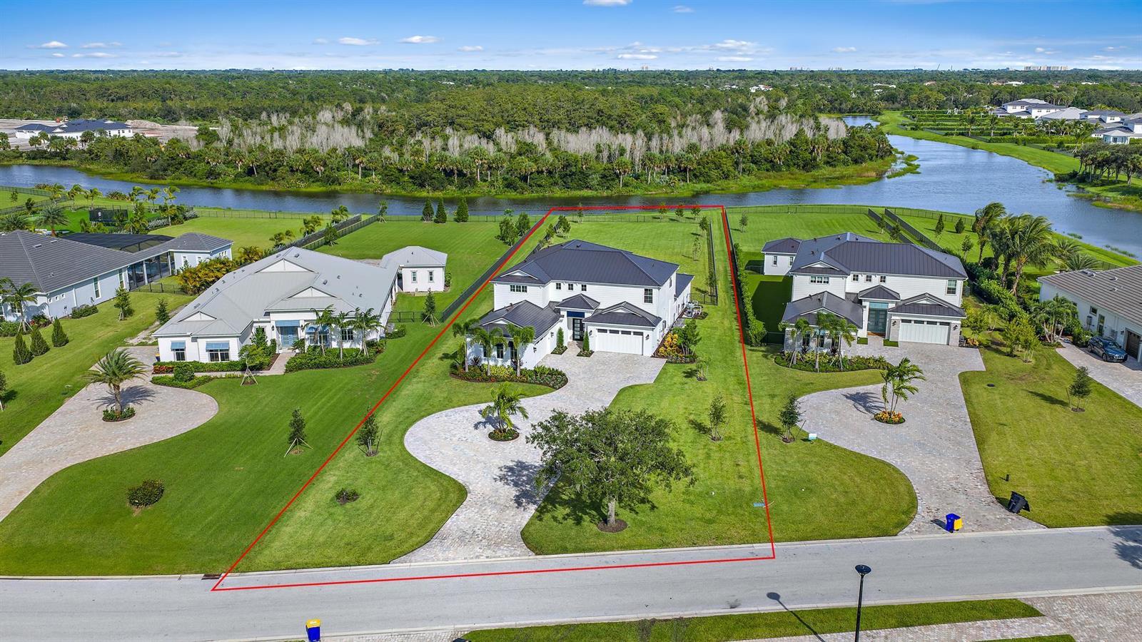 An aerial view shows a large white house with a dark roof and paved driveway — 20037 SE Bridgewater Drive, Jupiter FL 33458, JUPITER, FL