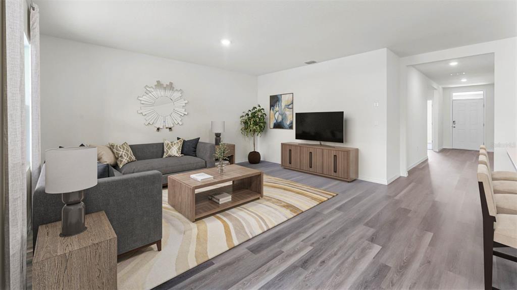 A living room features gray flooring, a sectional sofa, a coffee table, and a television — 5175 NICKERBEAN STREET, APOPKA, FL
