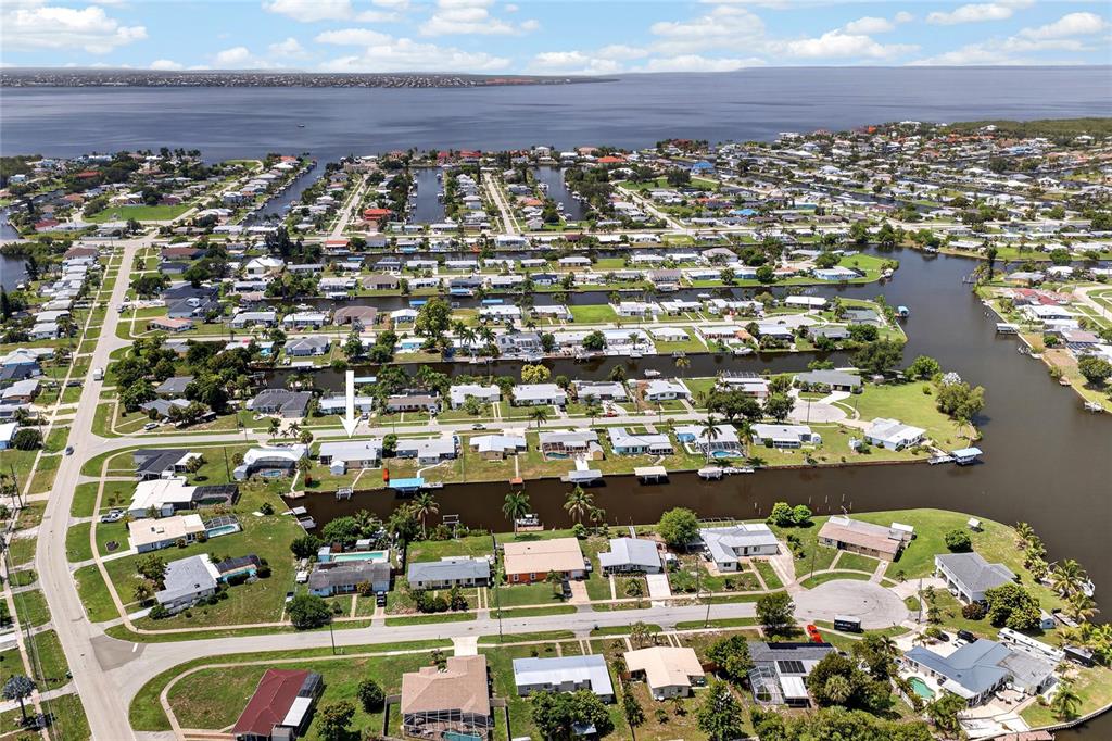 An aerial view shows a residential neighborhood with houses situated along several narrow canals — 321 WEBER TERRACE, PORT CHARLOTTE, FL