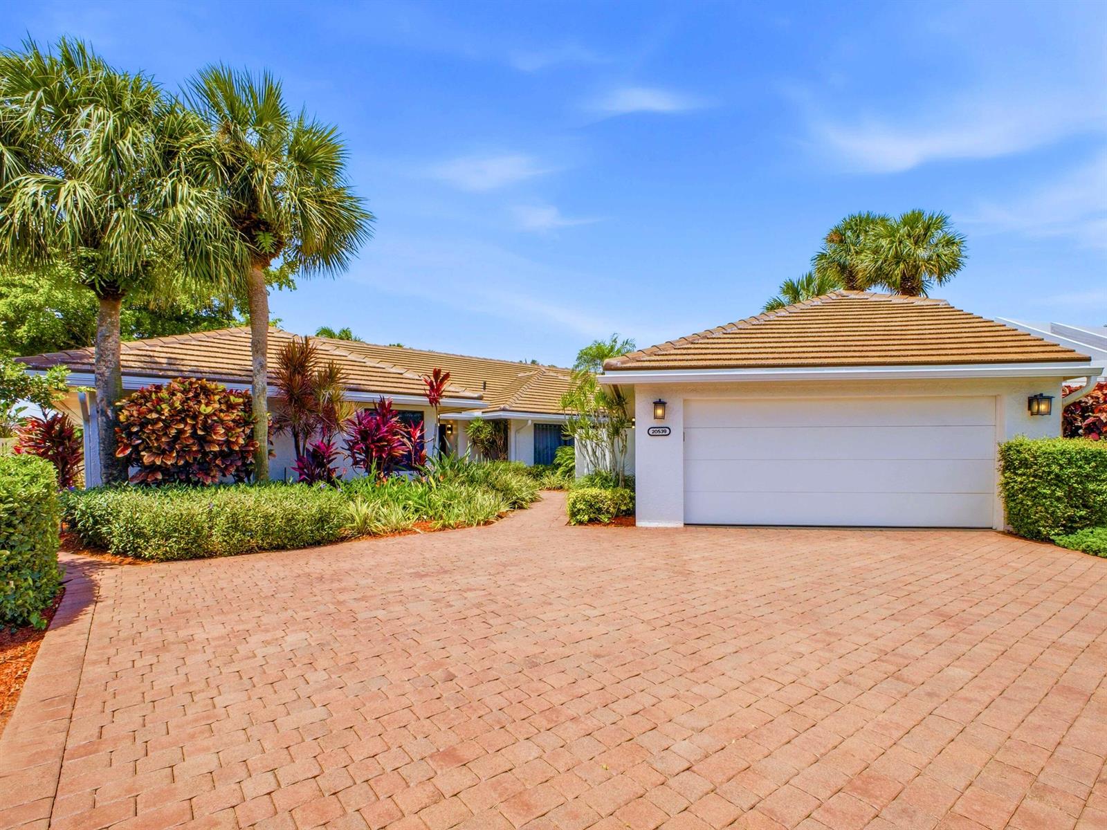 A single-story house with a white garage, a tiled roof, and a brick paver driveway — 20539 Linksview Way, Boca Raton FL 33434, BOCA RATON, FL