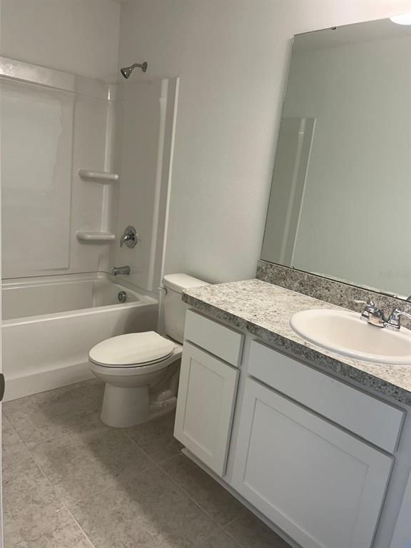 An empty room with gray carpet, white walls, and a window overlooking a pond — 3270 VESARA DRIVE, DAVENPORT, FL