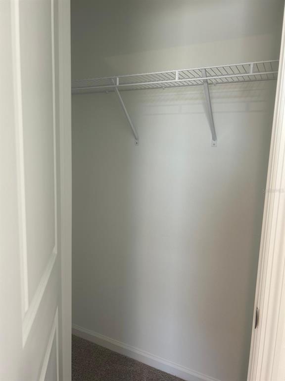 A kitchen features white cabinets, stainless steel appliances, granite countertops, and light-colored tile flooring — 3270 VESARA DRIVE, DAVENPORT, FL