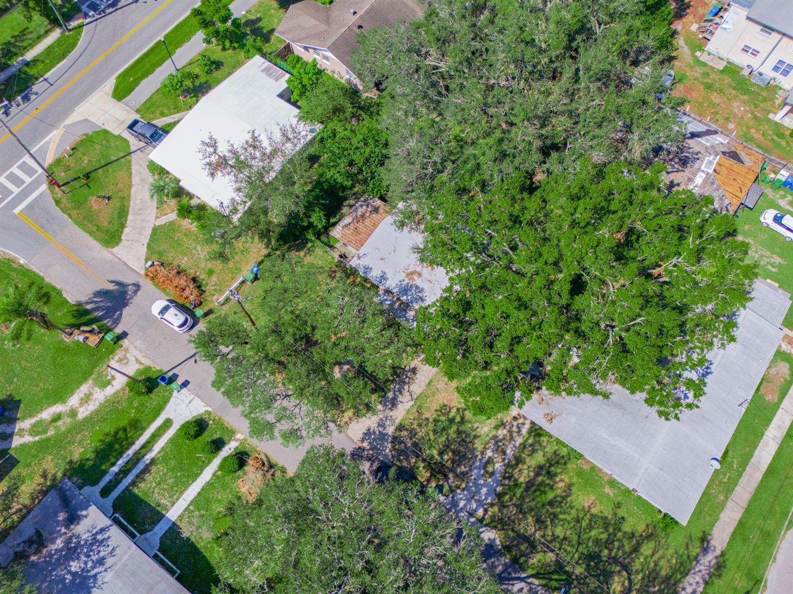 An aerial view shows a residential neighborhood with houses, large trees, and paved streets — 657 Ave C SW, Winter Haven FL 33880, WINTER HAVEN, FL
