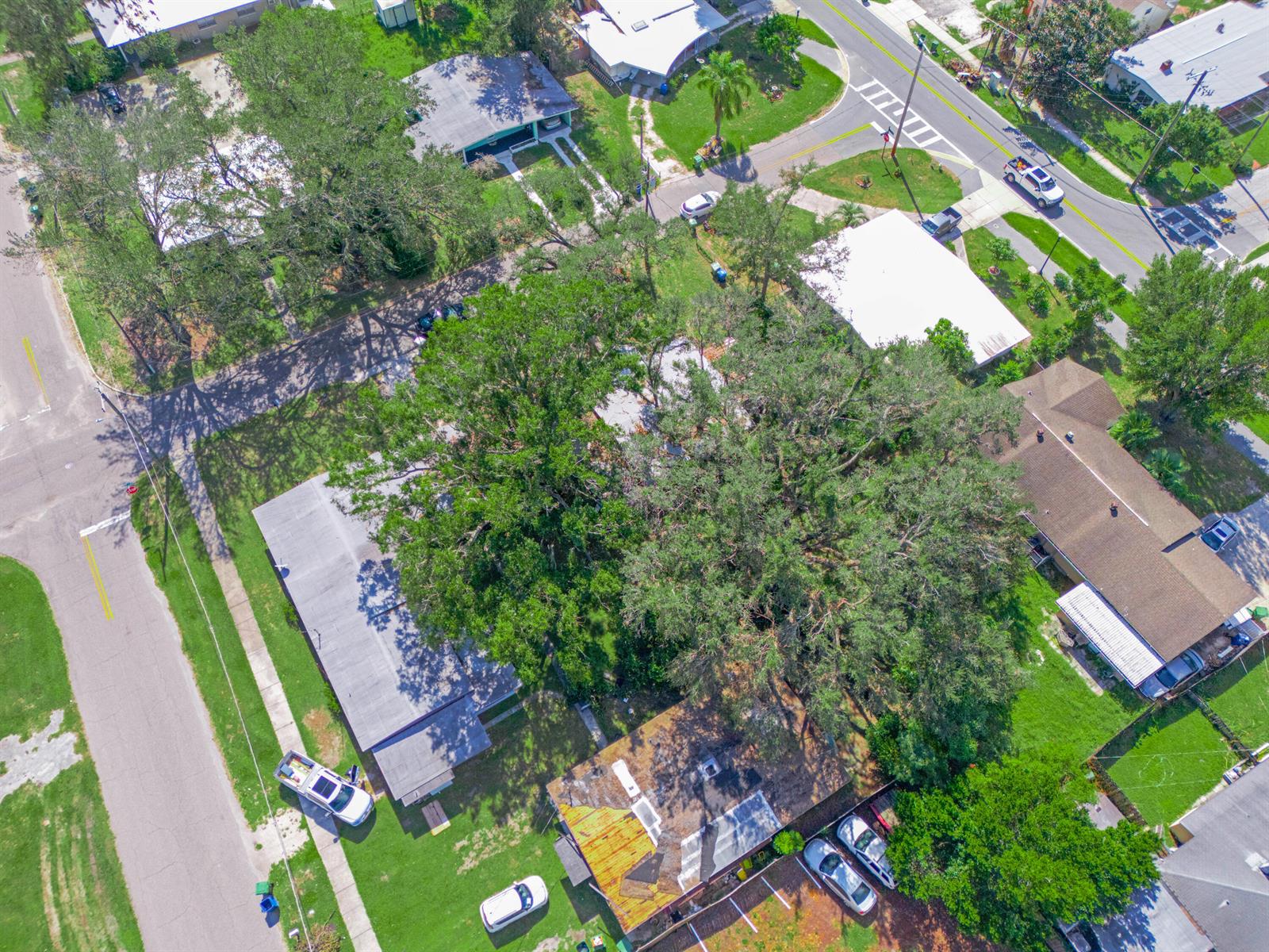 An aerial view shows a residential neighborhood with houses, large trees, and parked cars — 657 Ave C SW, Winter Haven FL 33880, WINTER HAVEN, FL