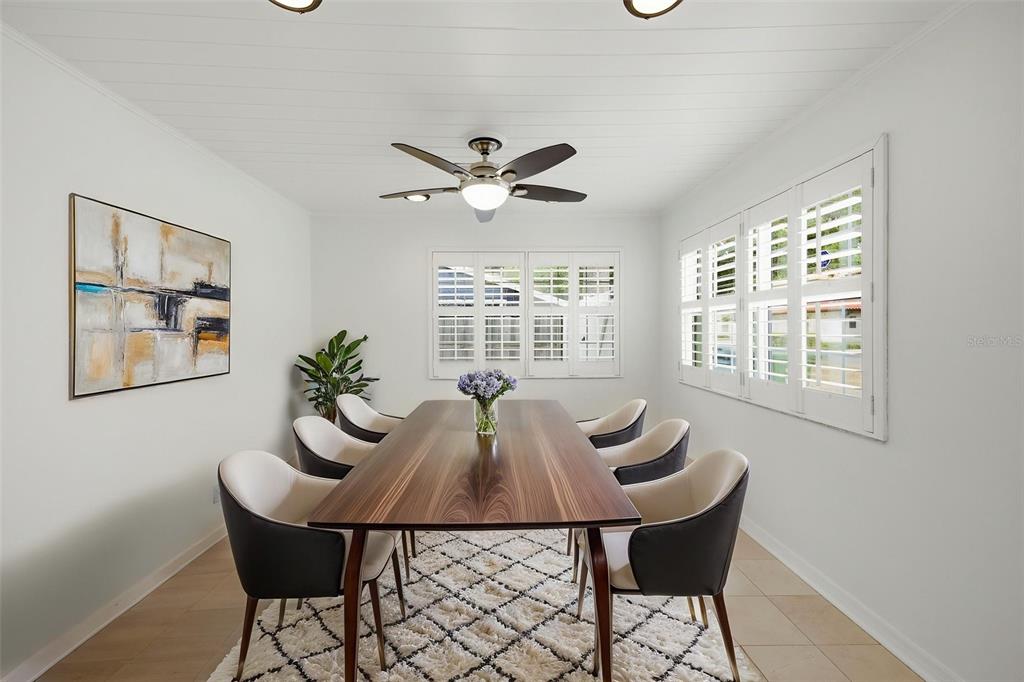 A dining room features a wooden table, six chairs, a ceiling fan, and plantation shutters — 2512 W KANSAS AVENUE, TAMPA, FL