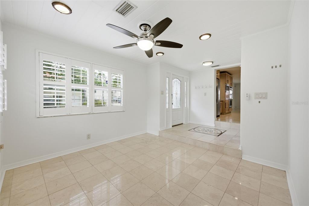 A bright room with light tile floors, a ceiling fan, and a raised entryway — 2512 W KANSAS AVENUE, TAMPA, FL