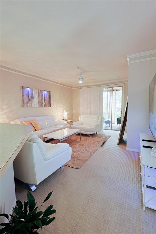 A living room features white leather furniture, a coffee table, and a sliding glass door — 4166 CENTRAL SARASOTA PARKWAY UNIT 512, SARASOTA, FL