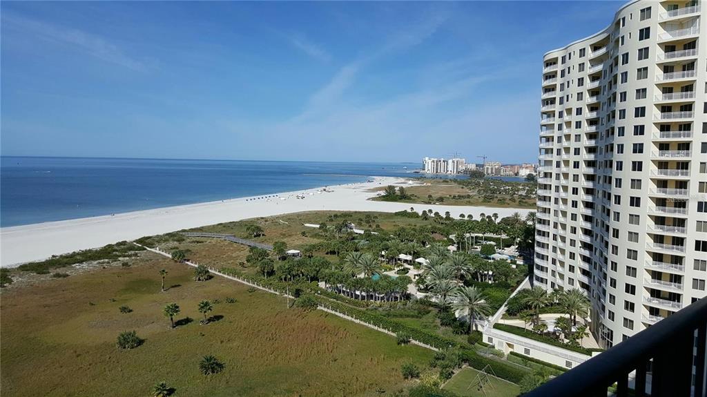 An elevated view of a beach, coastal vegetation, and a high-rise residential building — 1230 GULF BOULEVARD UNIT 1601, CLEARWATER BEACH, FL