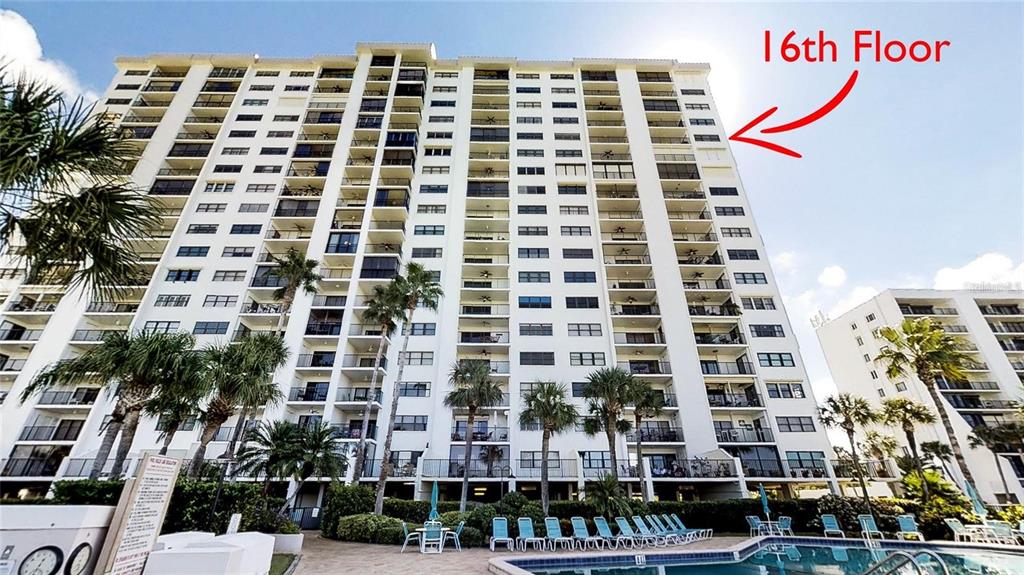 A tall, multi-story residential building features numerous balconies and an outdoor swimming pool below — 1230 GULF BOULEVARD UNIT 1601, CLEARWATER BEACH, FL