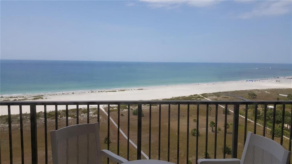 A balcony with two chairs overlooks a sandy beach and the ocean — 1230 GULF BOULEVARD UNIT 1601, CLEARWATER BEACH, FL