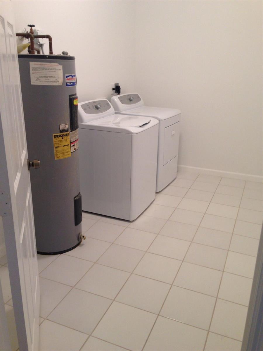 A laundry room features a water heater, a white washing machine, and a white dryer — 1731 Lavue Avenue, FL 33460, FL