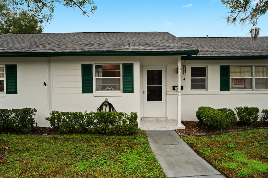 A single-story white house with green shutters and a front walkway — 241 N HILL AVENUE, DELAND, FL