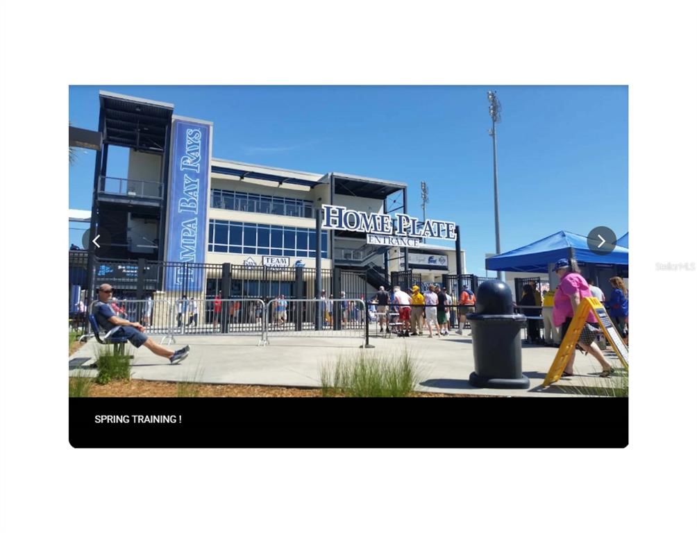 The exterior of a stadium entrance features a large sign reading Home Plate Entrance — KALSTED STREET, NORTH PORT, FL
