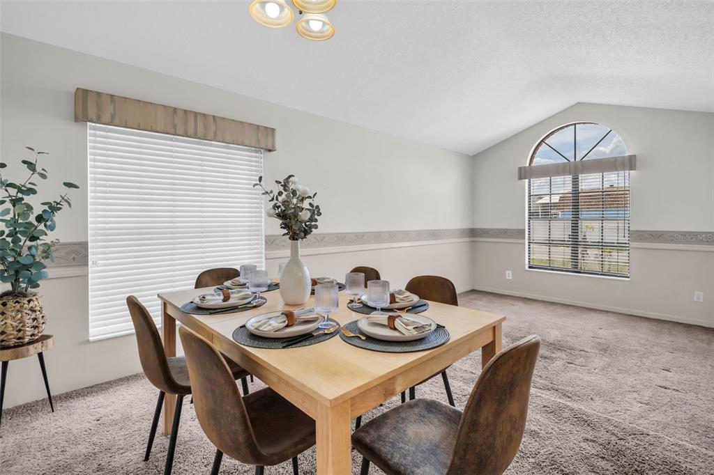 A dining room features a light wood table, six chairs, carpeted floors, and two windows — 5341 SOUTHWICK DRIVE, TAMPA, FL
