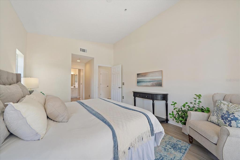A bedroom features a bed, an armchair, a console table, and an attached bathroom — 4256 CENTRAL SARASOTA PARKWAY UNIT 321, SARASOTA, FL