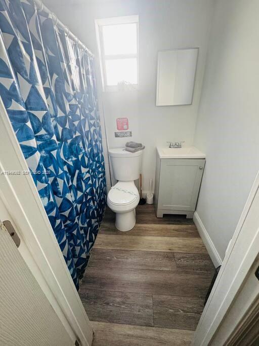 A small bathroom features a blue patterned shower curtain, a white toilet, and a vanity — 7638 N Miami Avenue # 4, Miami FL 33150, MIAMI, FL