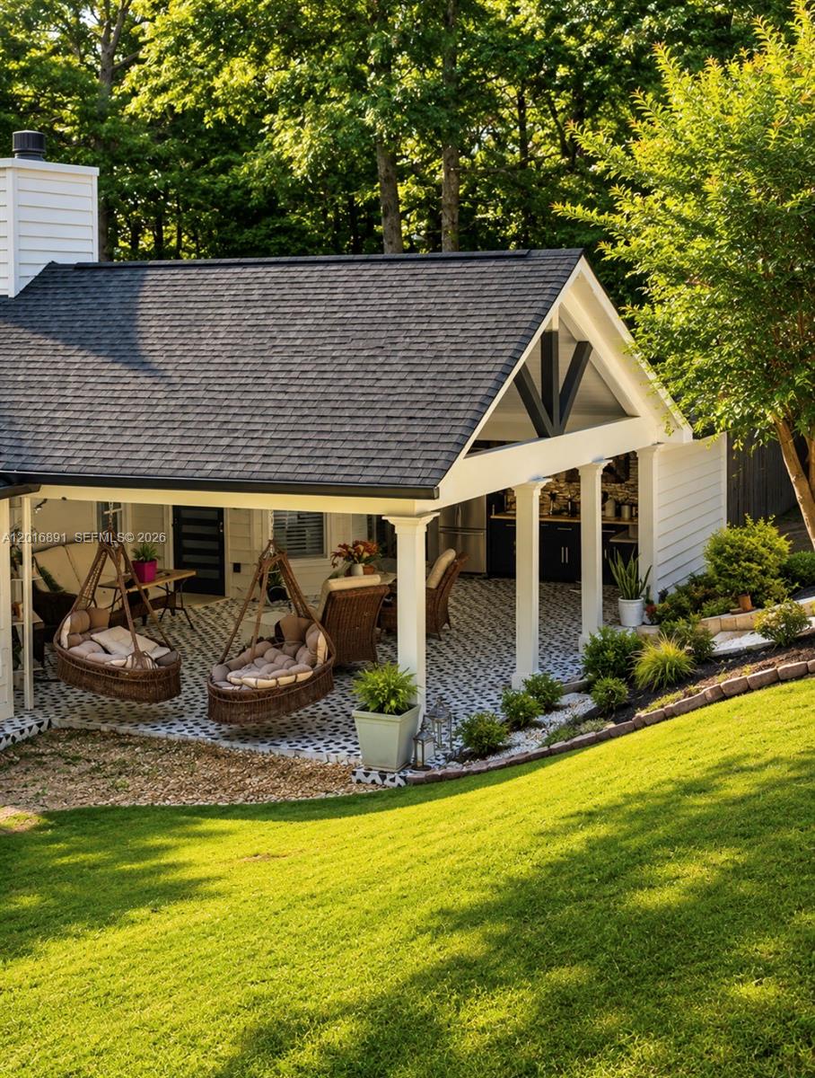 A covered outdoor patio features hanging wicker chairs, patterned tile flooring, and white columns — 1393 Sutters Walk, GA 30045, GA