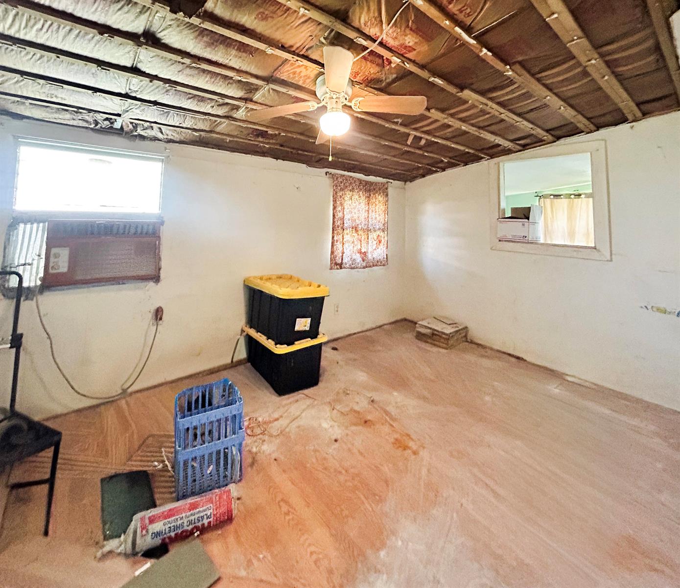 An unfinished room features exposed ceiling joists, insulation, a ceiling fan, and bare subflooring — 17202 Broadland Lane, Okeechobee FL 34974, OKEECHOBEE, FL